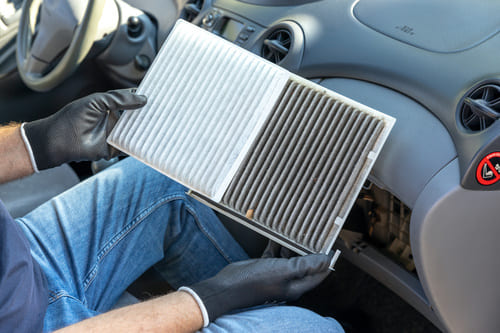 車のエアコンが効かない場合に、エアコンフィルターを確認している画像。汚れたエアコンフィルターときれいなエアコンフィルターを比較している